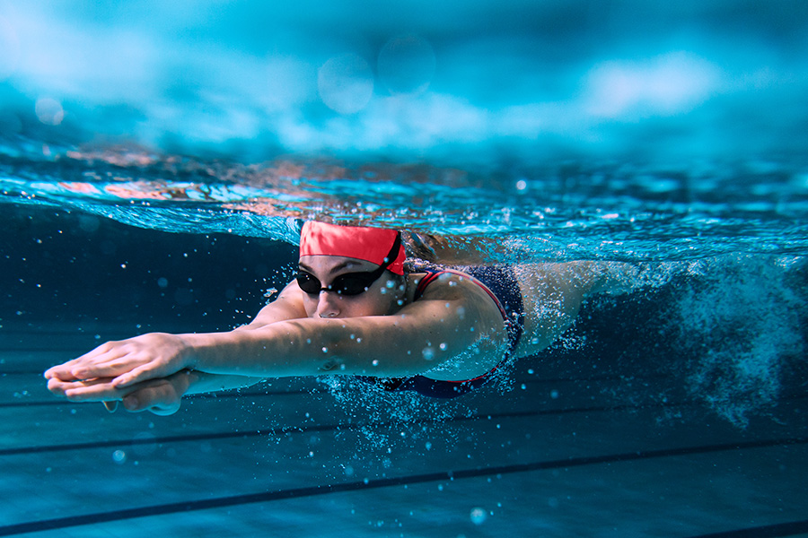 Eine Schwimmerin schwimmt im Pool eine Bahn